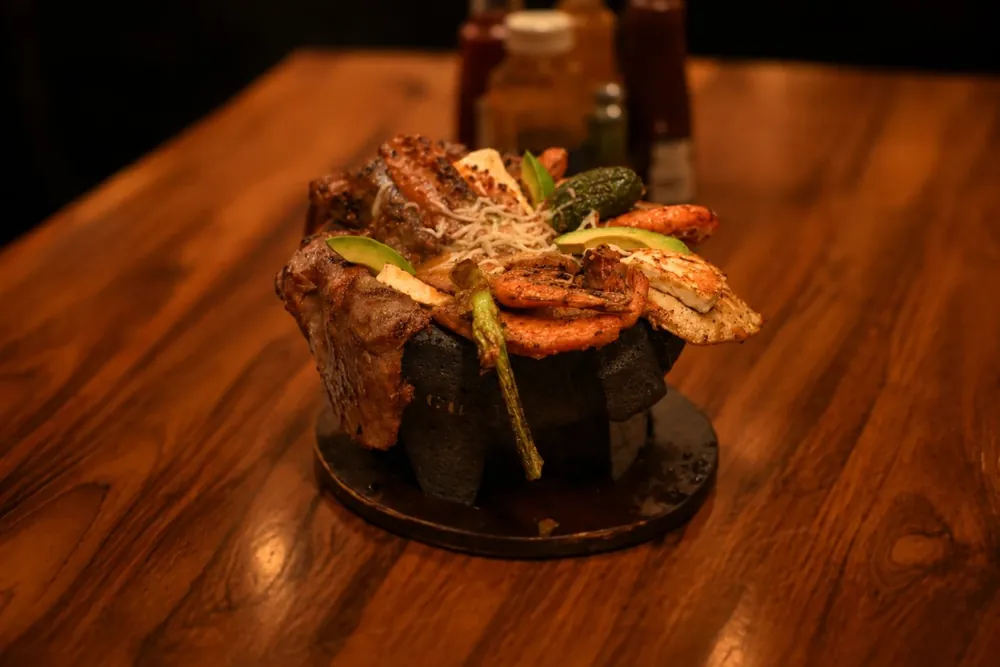 Molcajete Cielo: Mar y Tierra — chicken, beef, chorizo and shrimp in a stone molcajete