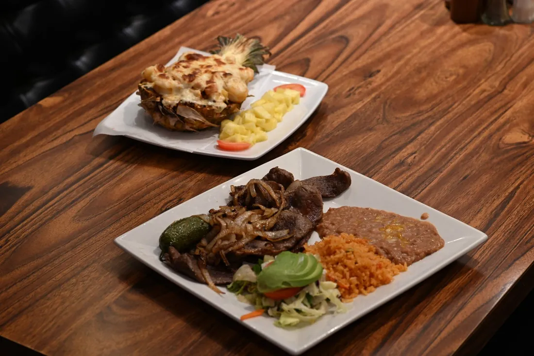 Carne asada plate with grilled onions, jalapeño, avocado, rice and refried beans